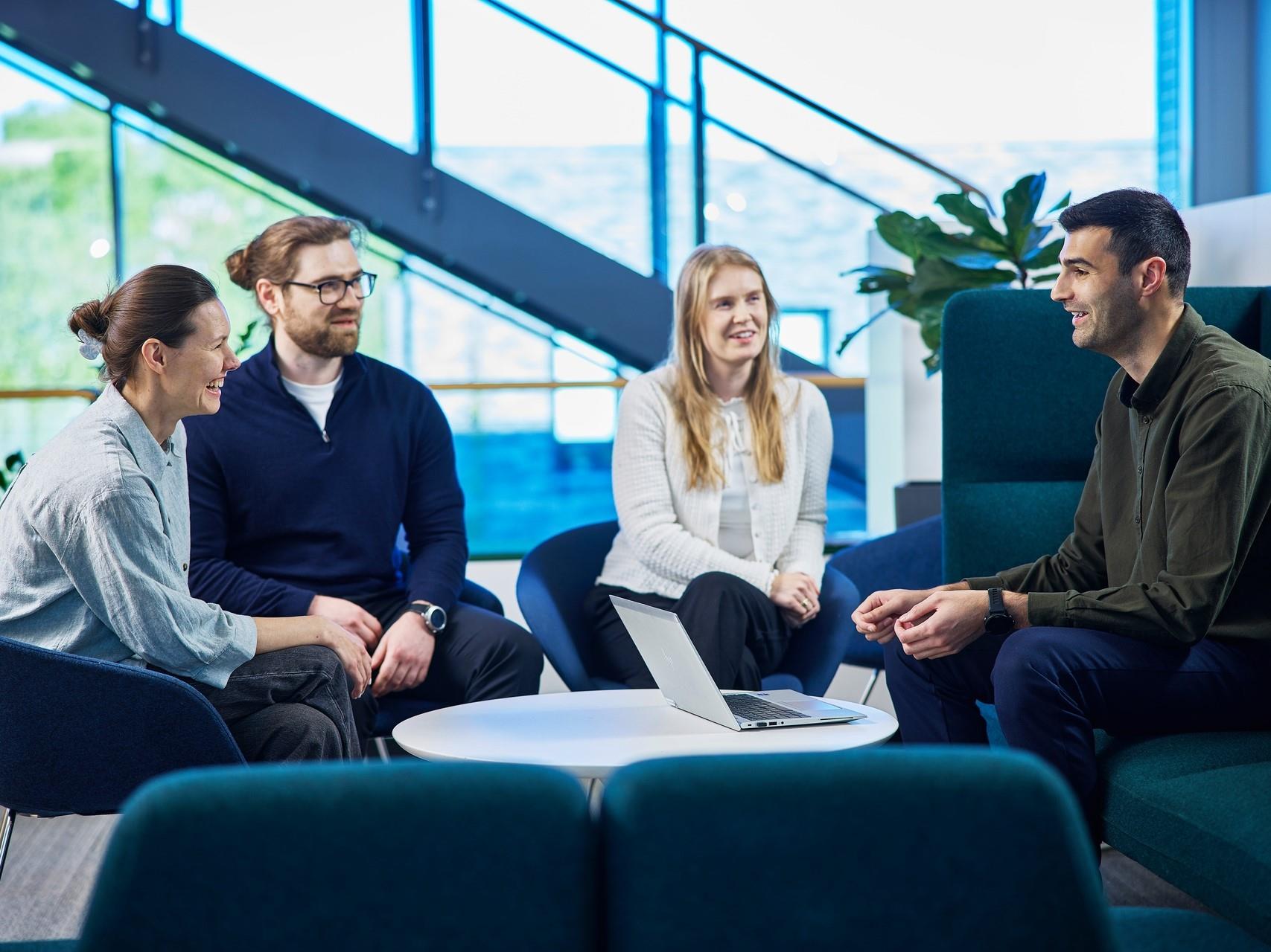 Fire mennesker rundt et bord